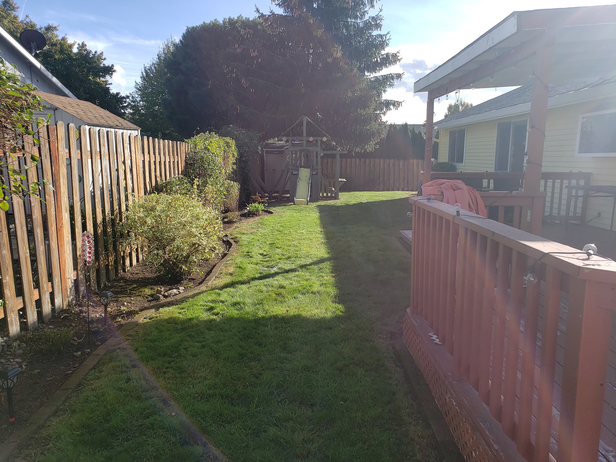 A cleaned up backyard lawn and play area after a full property clean-out